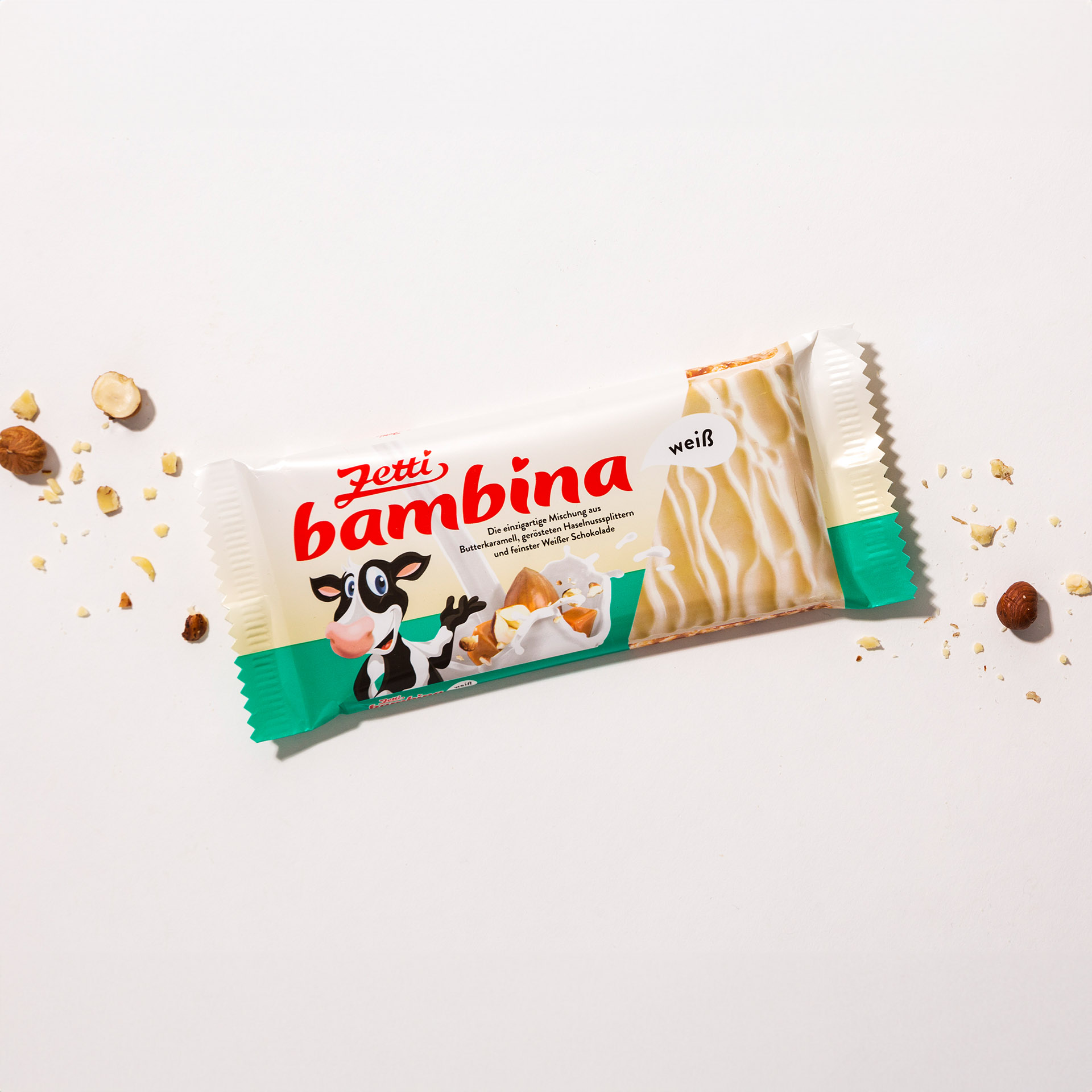 Eine Tafel Zetti Bambina weiß eingebettet in Haselnüssen